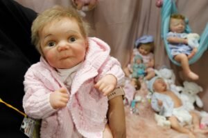 Imagem colorida de mulher carregando bebê reborn