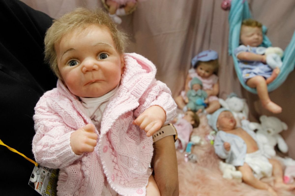 Imagem colorida de mulher carregando bebê reborn