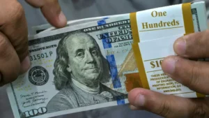 Dólar cai e Bolsa recua pressionada por balanços do varejo